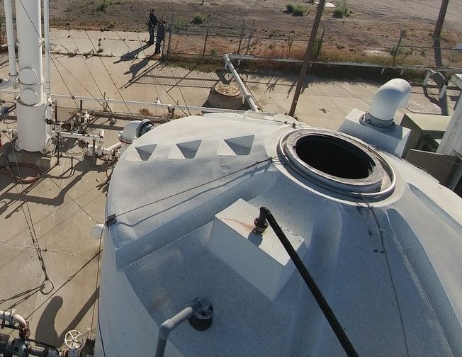 Treatment tank with open hatch